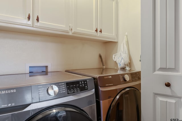 washroom with cabinets and washer and clothes dryer