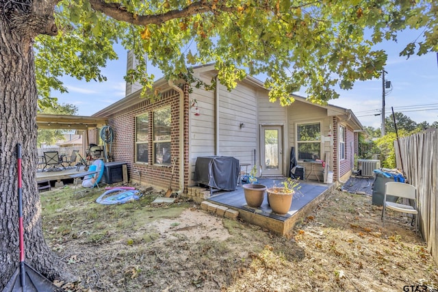 back of house featuring central air condition unit and a wooden deck