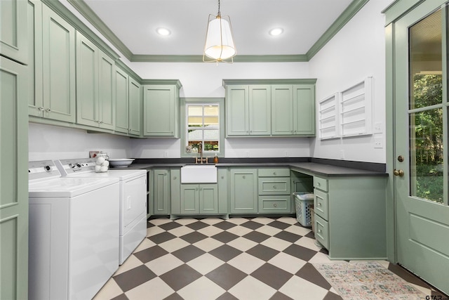 clothes washing area featuring cabinets, sink, washing machine and clothes dryer, and ornamental molding