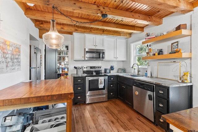 kitchen featuring wooden counters, pendant lighting, light wood-type flooring, appliances with stainless steel finishes, and white cabinetry