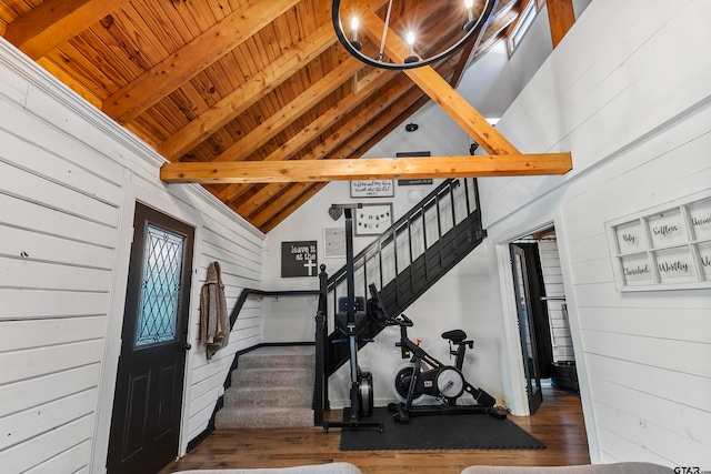 staircase with wooden ceiling, wood walls, beamed ceiling, high vaulted ceiling, and wood-type flooring