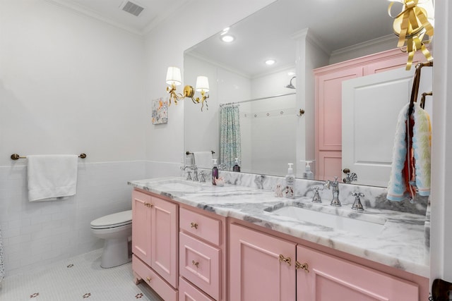 bathroom featuring tile walls, ornamental molding, vanity, tile patterned flooring, and toilet