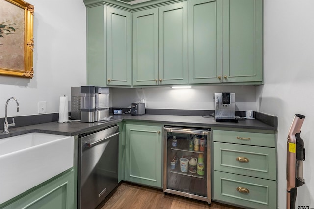 kitchen with stainless steel appliances, wood-type flooring, sink, and green cabinets