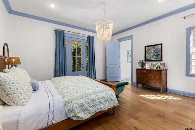 bedroom with an inviting chandelier, access to exterior, light hardwood / wood-style flooring, and crown molding