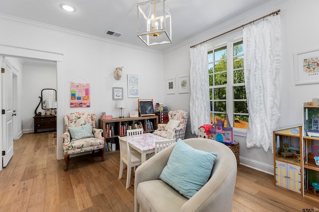 living area featuring light wood-type flooring, crown molding, and a notable chandelier