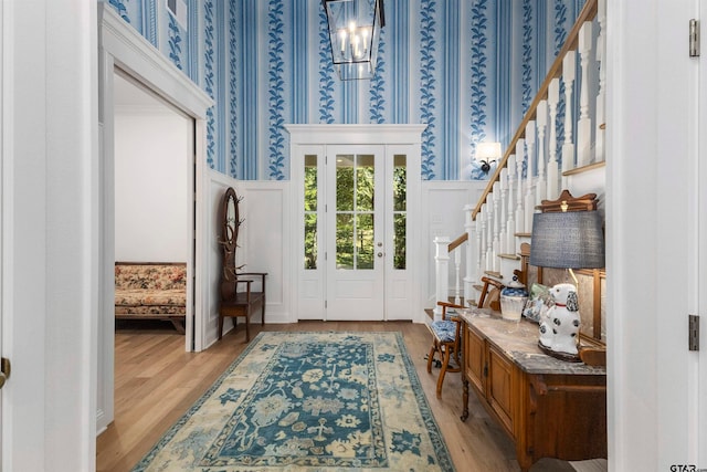 foyer entrance with light wood-type flooring and a notable chandelier