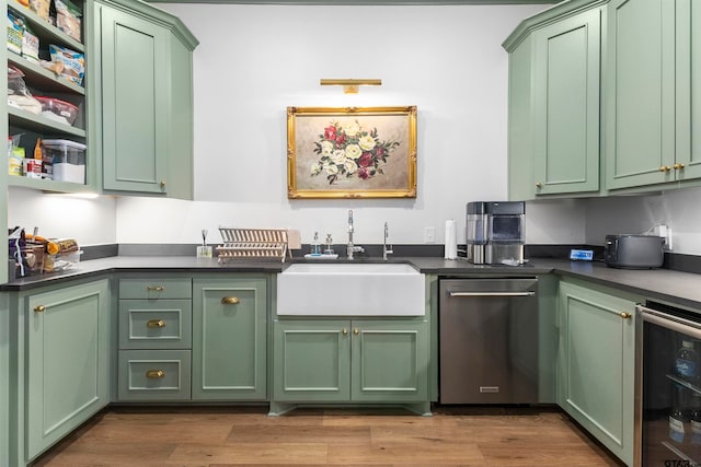 kitchen featuring stainless steel dishwasher, green cabinets, and sink