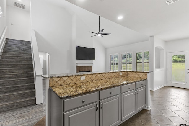 kitchen with high vaulted ceiling, dark tile patterned flooring, visible vents, ceiling fan, and gray cabinetry