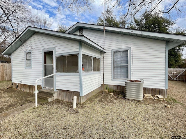 view of property exterior with a sunroom and central air condition unit