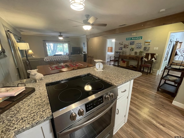 kitchen featuring hardwood / wood-style flooring, crown molding, white cabinetry, light stone countertops, and stainless steel electric stove