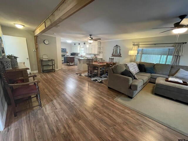 living room with hardwood / wood-style floors, beam ceiling, and ceiling fan