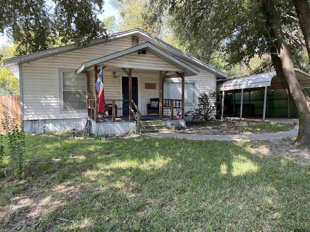 view of front of house with a front lawn, a carport, and covered porch