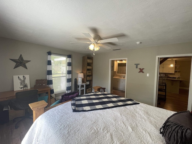 bedroom featuring a walk in closet, ceiling fan, dark wood-type flooring, a textured ceiling, and a closet