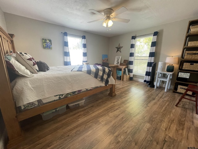 bedroom with hardwood / wood-style flooring, a textured ceiling, and ceiling fan