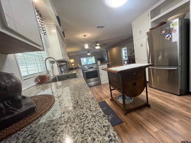 kitchen featuring white cabinetry, sink, stainless steel appliances, light stone countertops, and light hardwood / wood-style flooring