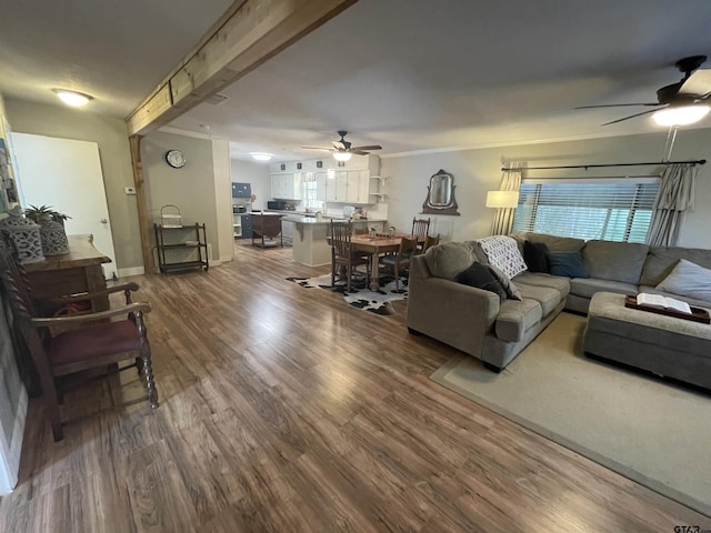 living room featuring hardwood / wood-style floors, beamed ceiling, and ceiling fan