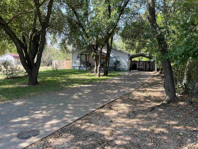 ranch-style house featuring a carport and a front lawn