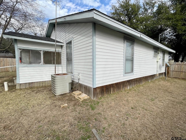 view of property exterior with a yard and central AC unit