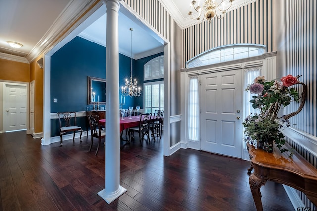 entryway with ornate columns, crown molding, dark hardwood / wood-style floors, and a notable chandelier