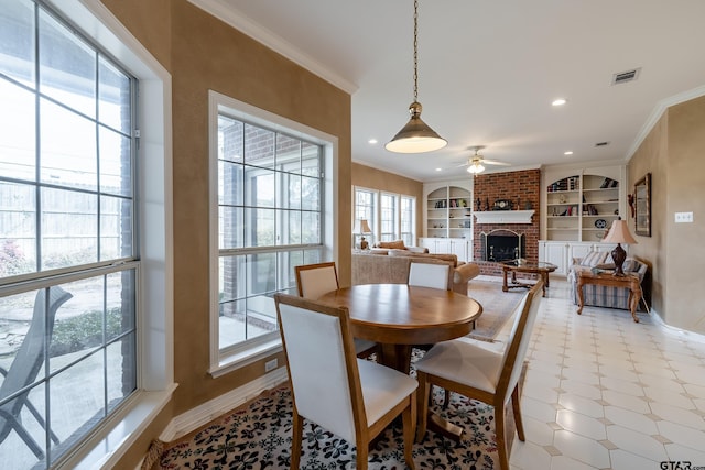 dining area with ceiling fan, crown molding, built in features, and a fireplace