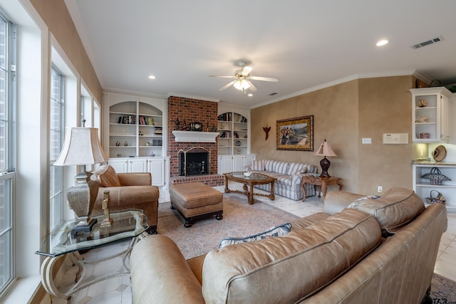 tiled living room featuring a fireplace, built in features, ceiling fan, and ornamental molding