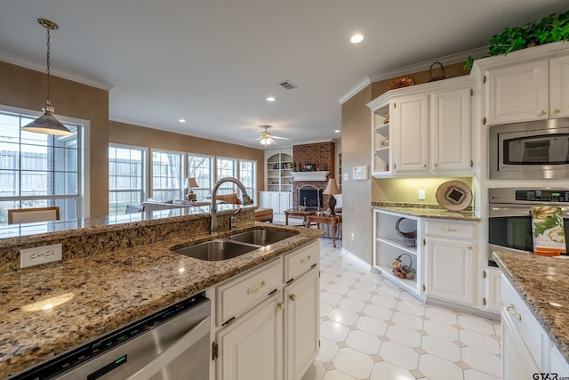 kitchen featuring appliances with stainless steel finishes, white cabinetry, ceiling fan, and sink