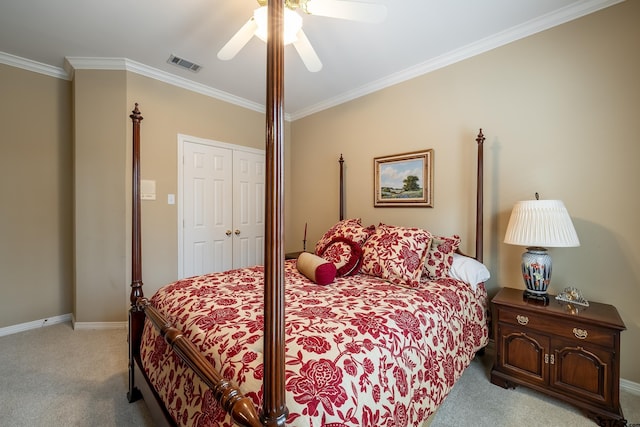 carpeted bedroom with ceiling fan, crown molding, and a closet