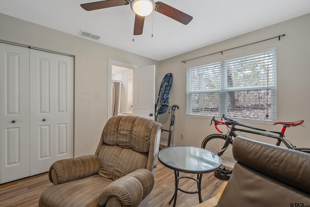 living area with light hardwood / wood-style flooring, ceiling fan, and a healthy amount of sunlight