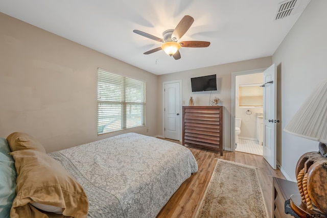 bedroom featuring a closet, ensuite bathroom, light hardwood / wood-style flooring, and ceiling fan