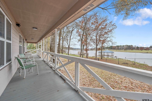 deck with a water view and covered porch