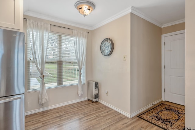 entryway with light hardwood / wood-style floors, heating unit, and crown molding