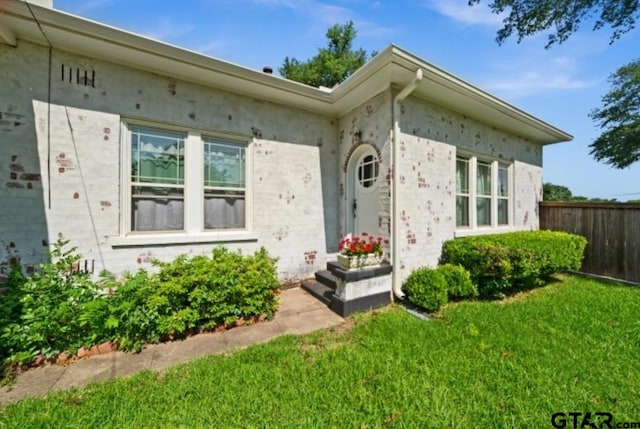 property entrance with a lawn