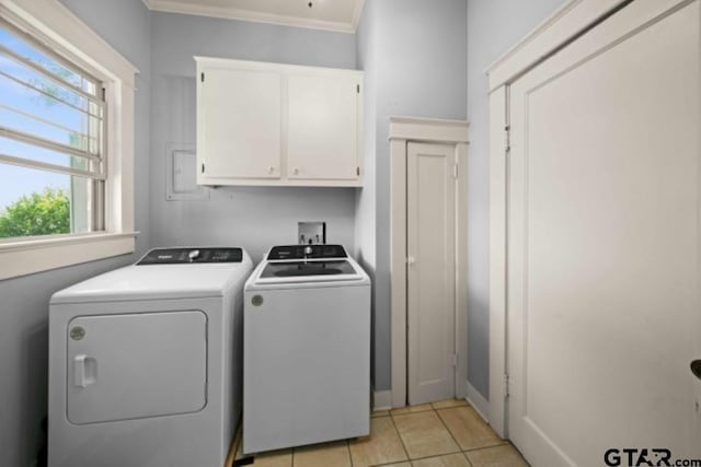 laundry room featuring cabinets, ornamental molding, light tile patterned floors, and washing machine and clothes dryer