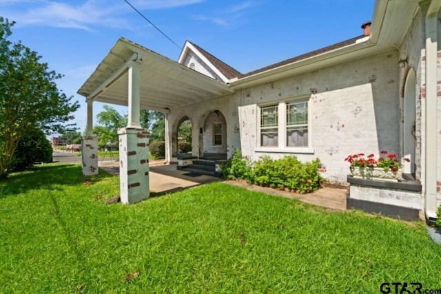 rear view of property featuring a lawn and a porch