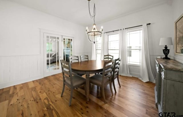 dining area with hardwood / wood-style floors and a chandelier