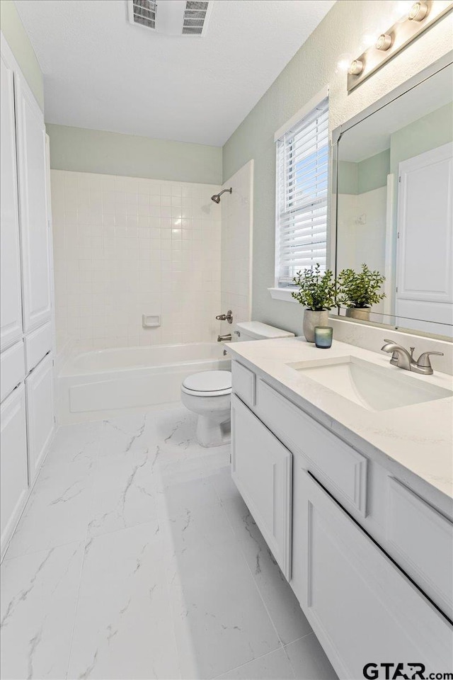 full bathroom with tiled shower / bath combo, vanity, and toilet