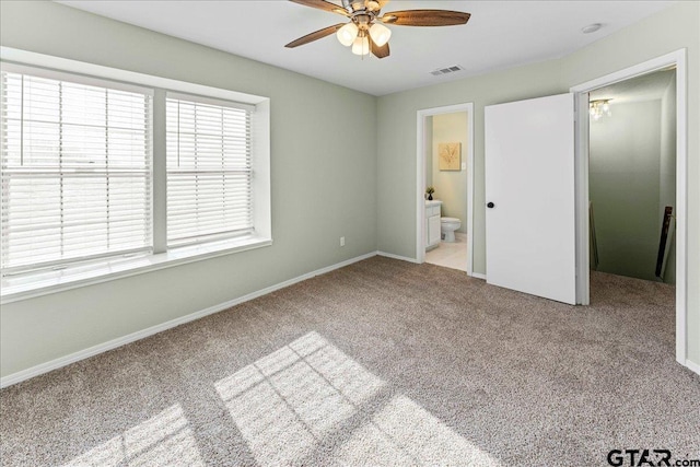 unfurnished bedroom featuring connected bathroom, light carpet, and ceiling fan