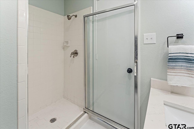 bathroom with walk in shower and vanity