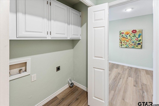 washroom featuring cabinets, hookup for an electric dryer, and light wood-type flooring