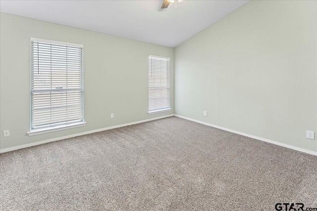 carpeted spare room featuring ceiling fan and vaulted ceiling