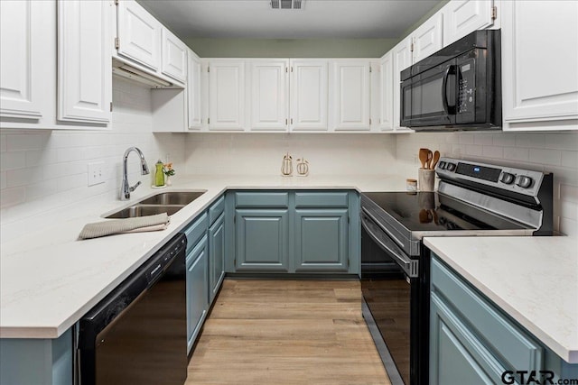 kitchen featuring sink, white cabinets, black appliances, blue cabinetry, and light hardwood / wood-style flooring