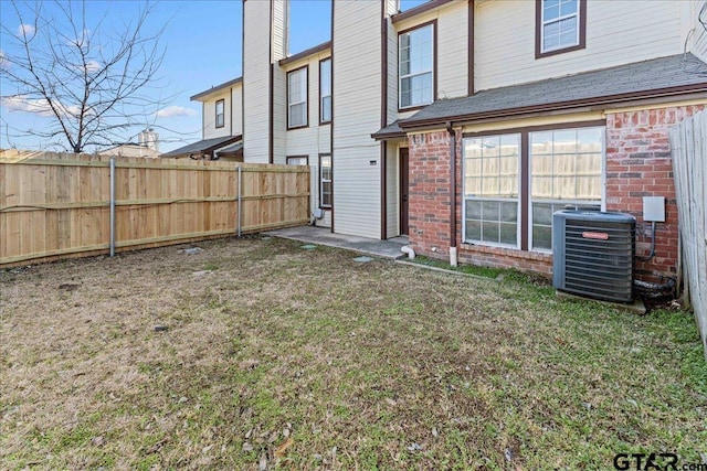 rear view of property with a lawn and central air condition unit