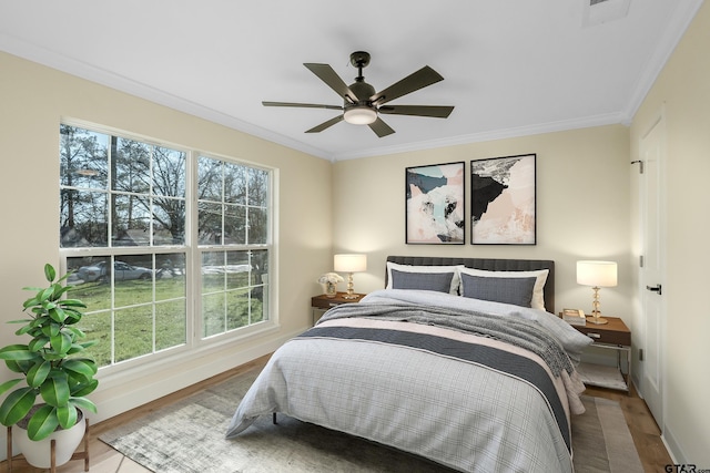 bedroom featuring hardwood / wood-style flooring, ceiling fan, and crown molding