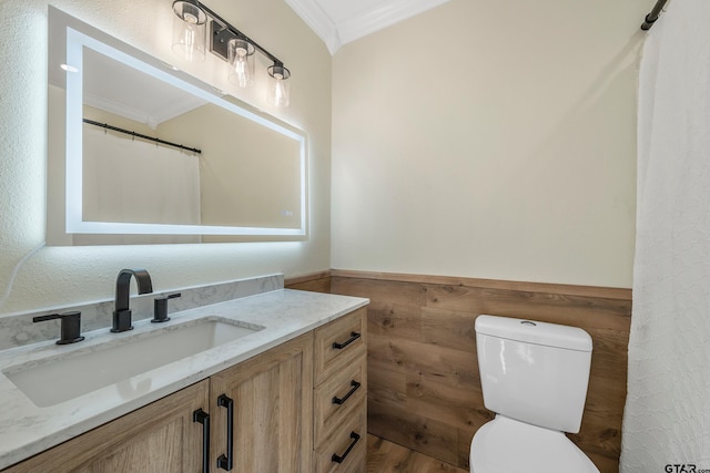 bathroom with vanity, toilet, and ornamental molding