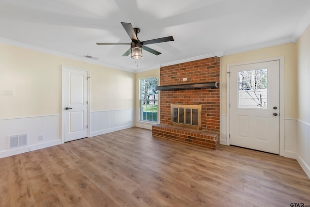 unfurnished living room with a fireplace, crown molding, and light hardwood / wood-style flooring