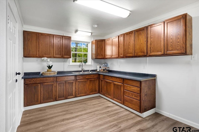 106 Peterson Pl, Longview, TX 75602 - kitchen featuring dark countertops, light wood-style flooring, and brown cabinetry
