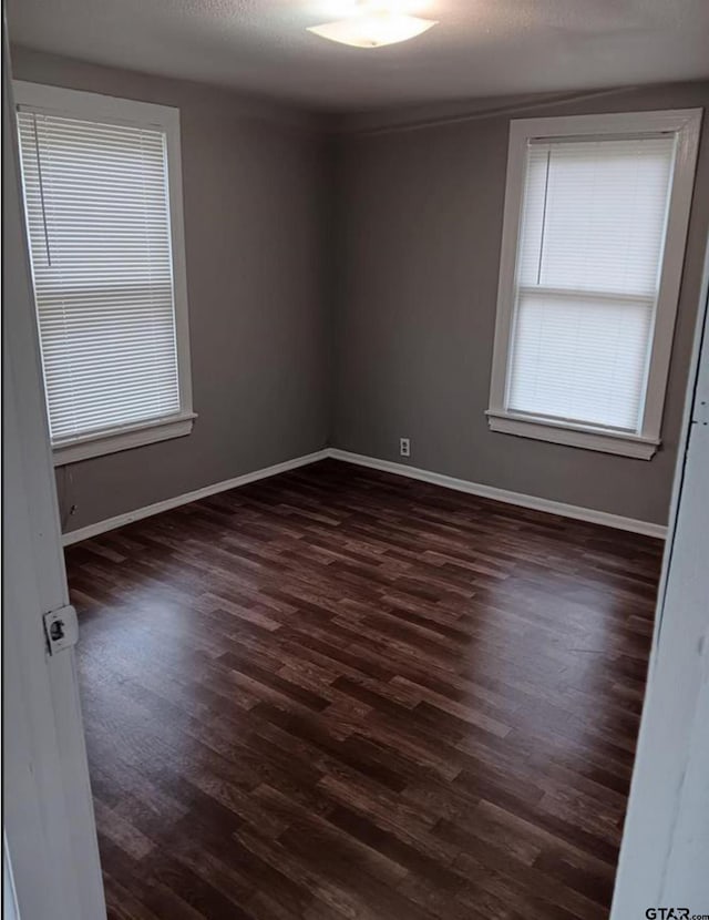 7094 Eleanor St, Tyler, TX 75708 - spare room featuring dark wood-style flooring, baseboards, and healthy amount of natural light