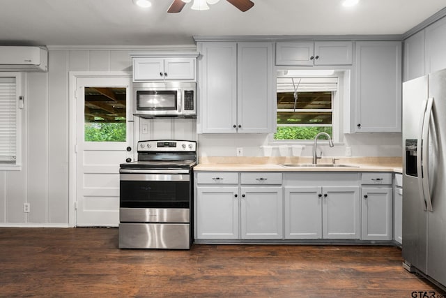 2811 Rollingwood Dr, Tyler, TX 75701 - kitchen with appliances with stainless steel finishes, a sink, a wall mounted air conditioner, a ceiling fan, and light countertops