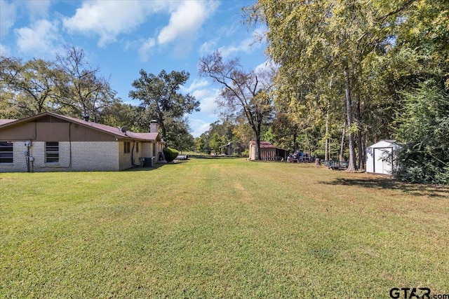 view of yard featuring cooling unit and a storage shed