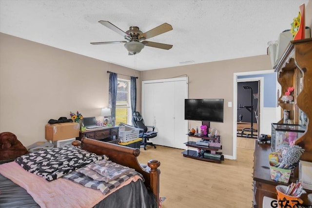 bedroom featuring ceiling fan, a closet, a textured ceiling, and light hardwood / wood-style flooring